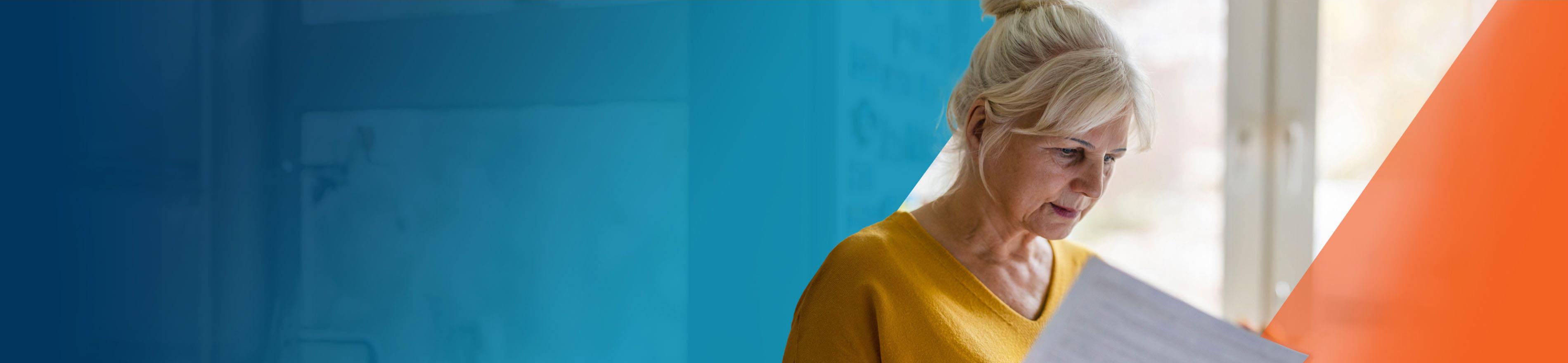 An older woman reviewing a booklet of OPDIVO® (nivolumab) and OPDIVO® + YERVOY® (ipilimumab) side effects.