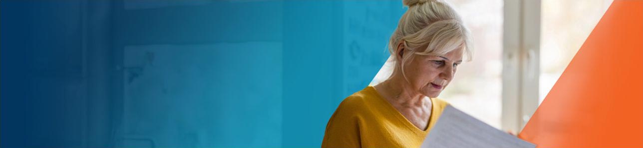 An older woman reviewing a booklet of OPDIVO® (nivolumab) and OPDIVO® + YERVOY® (ipilimumab) side effects.